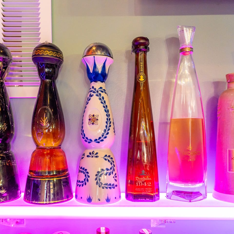 Premium tequila bottles on illuminated shelves.