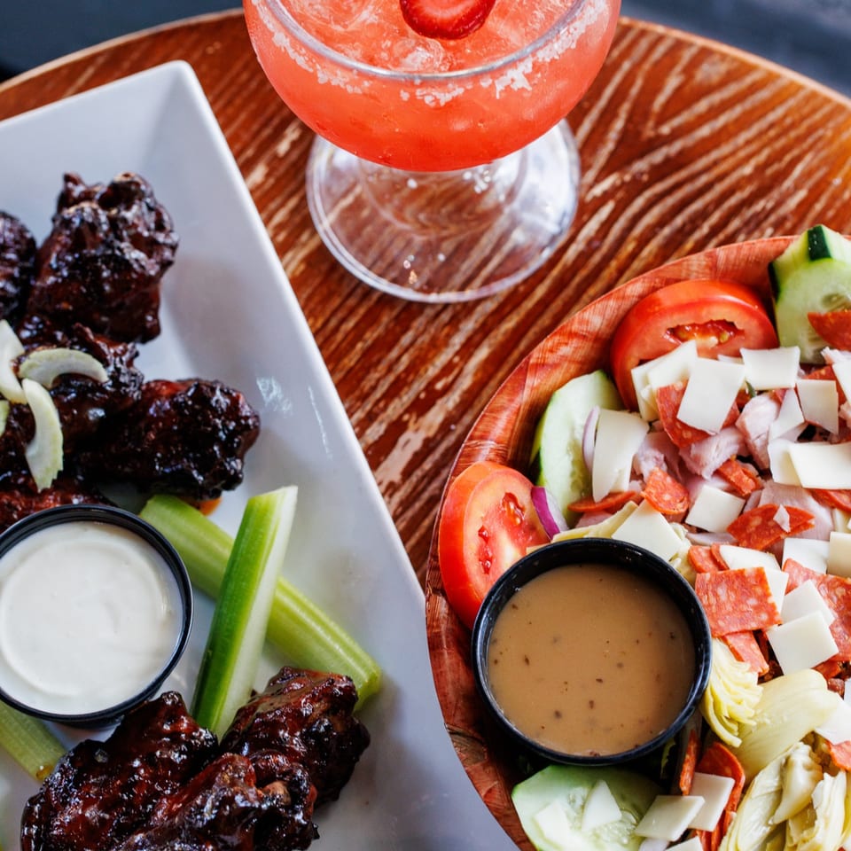 Glazed wings, salad, and a strawberry cocktail.