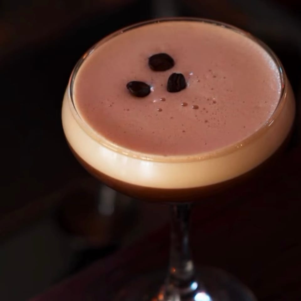 Espresso martini topped with coffee beans.